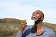 © PheelingsMedia - Happy man with black skin laughing drinking coffee