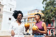 Smiling Black Women With Coconut Drinks
