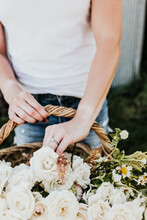 White Woman Reaches Hand Into Flower Basket