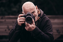 Portrait Of An Elderly Amateur Photographer Enjoying With His Camera