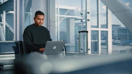 Airport Terminal: Indian IT Specialist, e-Commerce Businessman Uses Laptop Computer, Waiting for His Flight. Traveling Digital Entrepreneur Remote Work Online Sitting in Boarding Lounge of Airline Hub