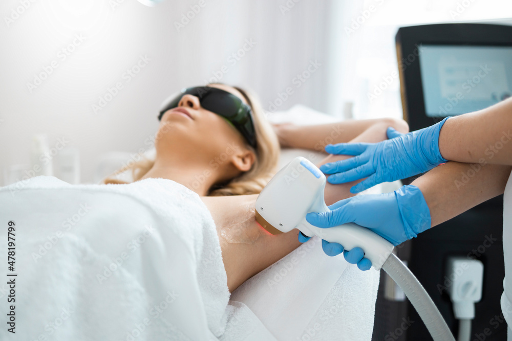 Epilation Radiology Woman on underarm laser epilation procedure in beauty clinic ...