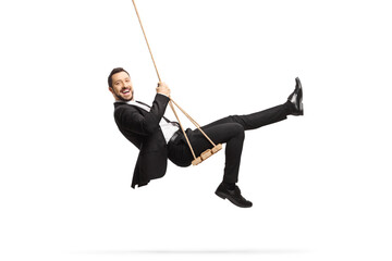 Full length side shot of a happy businessman swinging on a swing