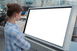 © zyabich - Woman in blue plaid shirt looking at blank interactive touchscreen white display of electronic kiosk at futuristic exhibition or museum. White screen, mock up, copyspace, template, technology concept.