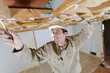 builder inspecting wooden ceiling joists