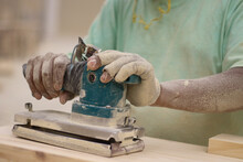 Worker Hands Polishing Wood With Machine