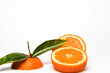 Cut Orange fruit with leaves isolated on white.