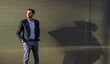 © ADDICTIVE STOCK - Serious businessman near wall on sunny street