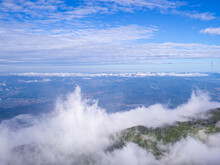 Scenic View Of The Mountains Against Fog, Clouds, And A Blue Sky
