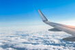 © Nancy Pauwels - Airplane wing above the clouds. View from airplane window. Air travel and transportation concept.