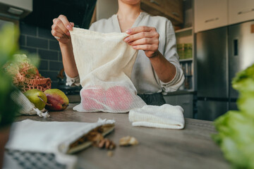 Wall Mural - Young woman holding the organic cotton reusable produce bag with peppers