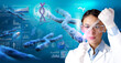 © Paulista - Female geneticist dropping sample from a pipette into a test-tube in abstract scientific background. Concept of DNA testing, biotech or human biology research.