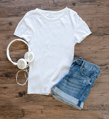 Wall Mural - Grey T-shirt and jeans mock up  with headphone flat lay on wooden background. Top front view