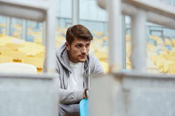 Poster - Sportsman sitting on seat on stadium and thinking