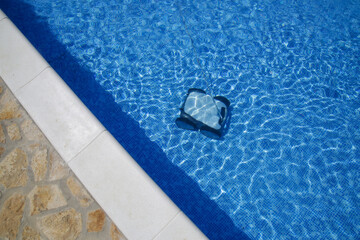 Cleaning the pool floor with an underwater vacuum cleaner, pool maintenance concept.