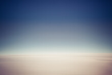 The Of A Clear Blue Sky With A Very Flat Featureless Cloudy Sky Below As Viewed From The Window Of A Jet.