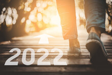 2022 New Year And Close Up Woman Walk In To The Wild With Sunset And Sunlight Background. Travel Adventure And Freedom Concept.