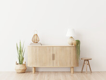 Living Room Wall Mockup In Warm Interior With Wooden Slat Curved Sideboard, Trendy Green Plant In Basket And Wicker Lantern On Blank White Background. 3D Rendering, Illustration