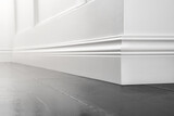 Fototapeta  - Close up of decorative, moulding white baseboard corner in empty room with copy space