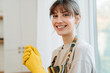 © Drobot Dean - White young woman in apron smiling while doing housework