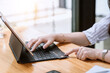 © amnaj - Close-up of a businesswoman hand using a tablet keyboard for online shopping with a credit card on the table.