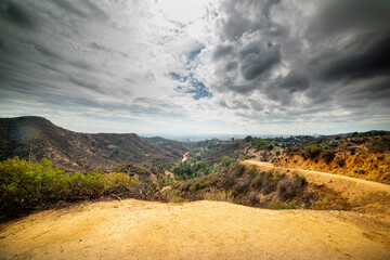 Wall Mural - Dramatic sky over Bronson Canyon with Los Angeles on the background