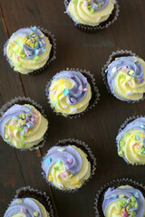 Poster - Yellow and purple easter cupcake on wooden background