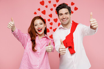 Wall Mural - Young fun couple two friends woman man in casual shirt look camera show thumb up like gesture isolated on plain pastel pink background studio portrait. Valentine's Day birthday holiday party concept.