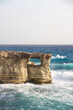 hole in cliff at famous sea caves at cape greco peninsula, cyprus