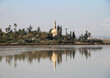 hala sultan tekke mosque at larnaca salt lake in cyprus, famous islamic monument, with reflection in water and blue sky