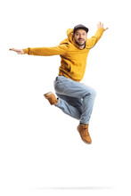 Young Man In A Yellow Sweatshirt Jumping And Smiling