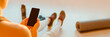 © Maridav - Fitness New Year resolution woman getting back in shape in 2022 using exercise app on phone for home workout. Banner panoramic of blank screen with yoga mat.