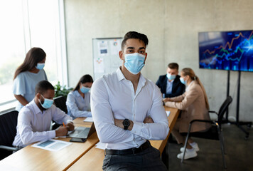 Poster - Middle eastern businessman wearing medical mask posing in office during corporate meeting