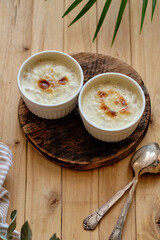 Sticker - Baked porridge with cream. Side view, wooden background