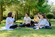 © Valerii Honcharuk - Outdoor, group of students with female teacher sitting on grass