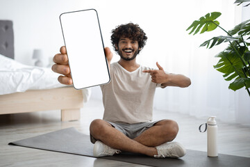 Happy indian guy showing smartphone with empty screen