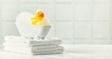 A Miniature Bubble Bath, Yellow Rubber Duck And White Towels On Bathroom Countertop, Children Bath Accessories, Baby Care