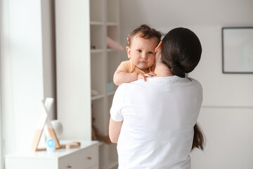 Poster - Young mother holding her little baby at home