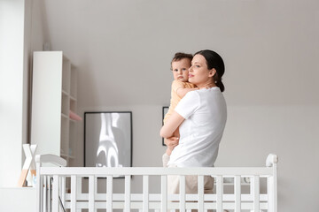 Sticker - Young mother holding her little baby in bedroom