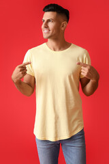 Poster - Handsome young man in stylish t-shirt on color background