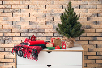 Wall Mural - Books with gifts, plaid and fir tree on chest of drawers in room. Christmas story