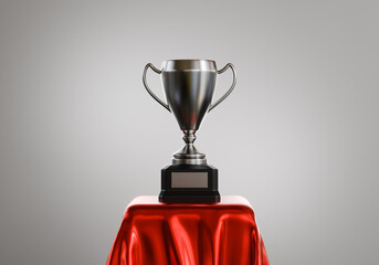 Gold trophy cup of first place and success award for winner champion on red podium. 3D rendering.