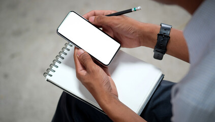 Young man sitting in home office and using smart phone..