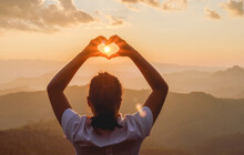 Silhouette Woman Doing Hands In Shape Of Love Heart Mountain Sunset Background.