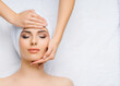 © Acronym - Young and healthy woman gets massage treatments for face, skin and neck in the spa salon. Health, wellness and rejuvenation concept.