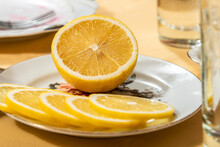 Half Of Lemon And Lemon Slices On A Plate On The Table.