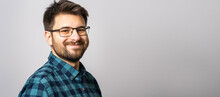 Portrait Of One Adult Caucasian Man 30 Years Old With Beard And Eyeglasses Looking To The Camera In Front Of White Wall Background Smiling Wearing Casual Shirt Copy Space