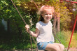 Happy child girl on swing, summer time. Life Events.  Retro toned, Soft focus effect