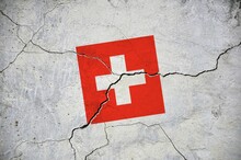 An Old Image Of The Flag Of Switzerland On A Wall With A Crack.