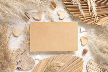 Blank Card On White Wooden Table Near Dried Plants, Palm Leaves, Pampas Grass And Hearts
